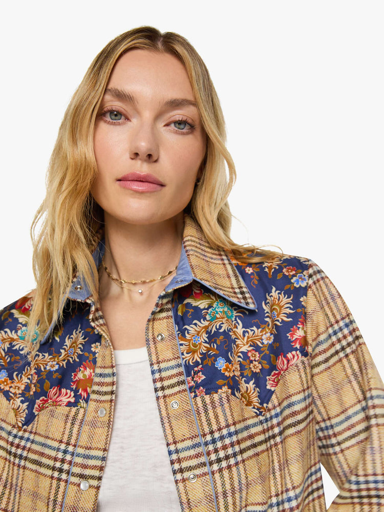 Close up view of a woman in a jacket is made from 100% wool in yellow and blue plaid with floral-print panels at the chest and wrists, and features a collared neck and slightly dropped shoulders.