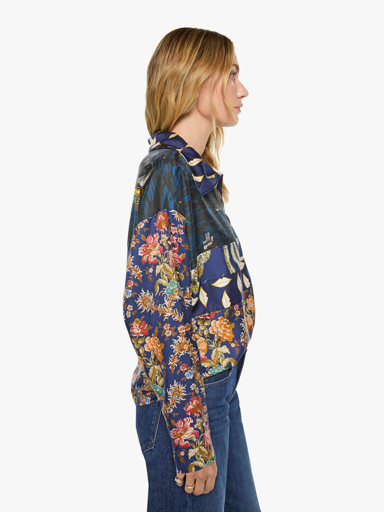 Side view of a woman in mix of graphic prints blouse with a collared V-neck, dropped shoulders, extra-long sleeves and a loose fit.