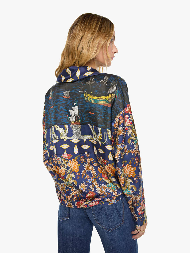 Back view of a woman in mix of graphic prints blouse with a collared V-neck, dropped shoulders, extra-long sleeves and a loose fit.