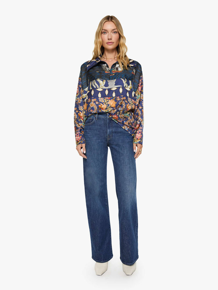 Full body view of a woman in mix of graphic prints blouse with a collared V-neck, dropped shoulders, extra-long sleeves and a loose fit.