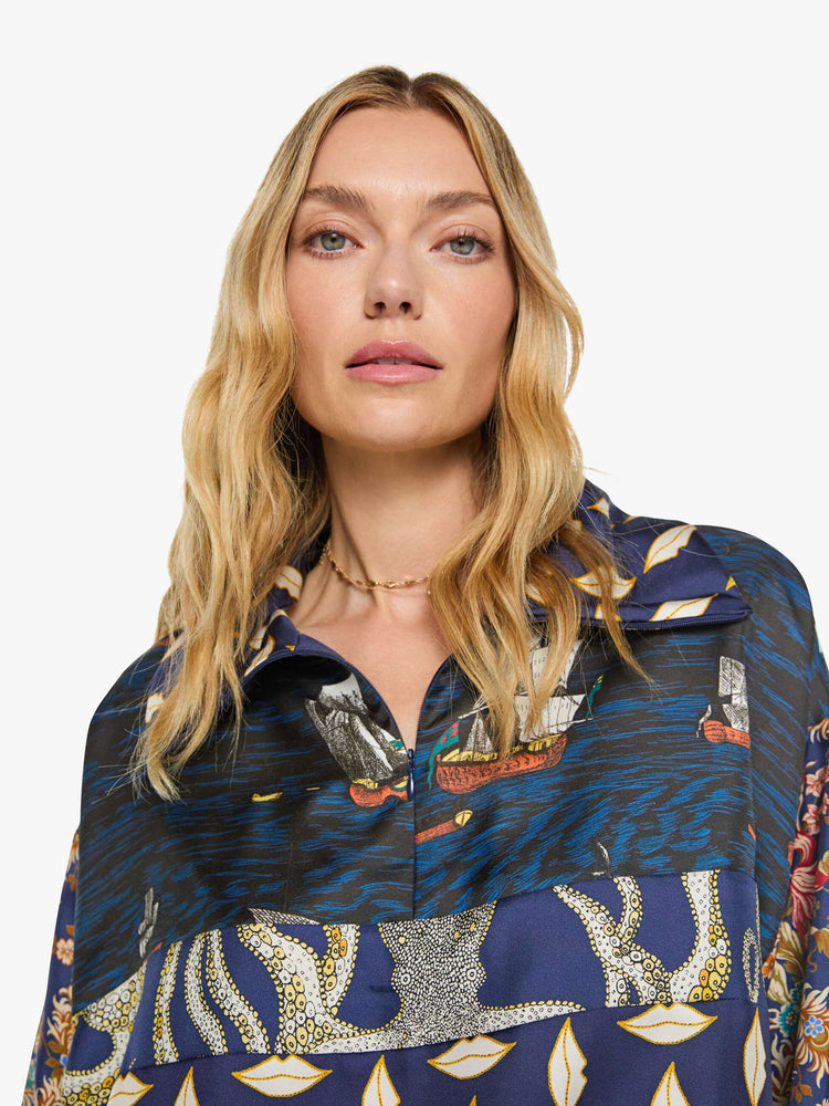 Close up view of a woman in mix of graphic prints blouse with a collared V-neck, dropped shoulders, extra-long sleeves and a loose fit.