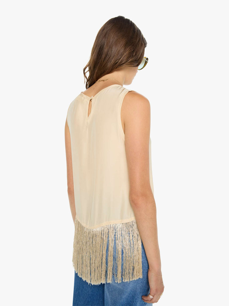 Back view of a woman in a top has a crew neck, side slits and a loose, cropped fit with long fringe at the hem.