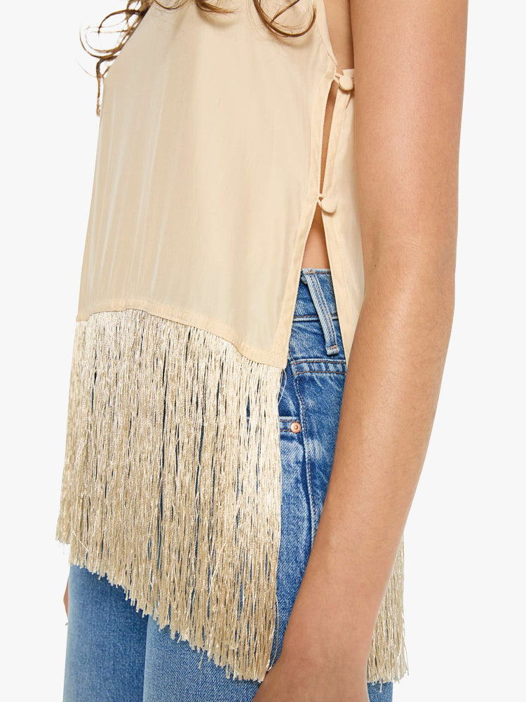 Close up view of a woman in a top has a crew neck, side slits and a loose, cropped fit with long fringe at the hem.