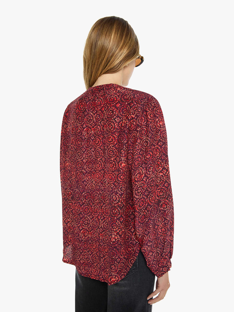 Back view of a woman deep red shirt with a floral print, and features a crewneck, long balloon sleeves and ruffles throughout for a flowy fit.