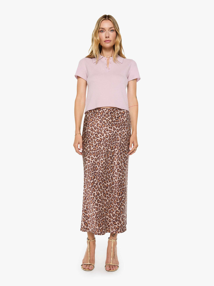 Full body view of a woman in pale pink top is designed with short sleeves, a collared V-neck that buttons and a boxy fit.