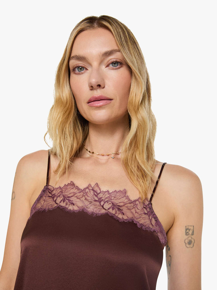 Close up view of a woman in a silk in a chocolate brown with lace trim, the cami is designed with a square neck, thin spaghetti straps and a loose, boxy fit.