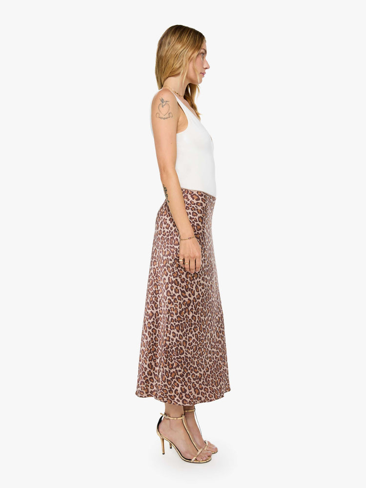 Side view of a woman in a cheetah print maxi skirt is designed with a straight fit and a flowy ankle-grazing hem.