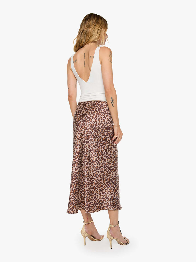 Back view of a woman in a cheetah print maxi skirt is designed with a straight fit and a flowy ankle-grazing hem.
