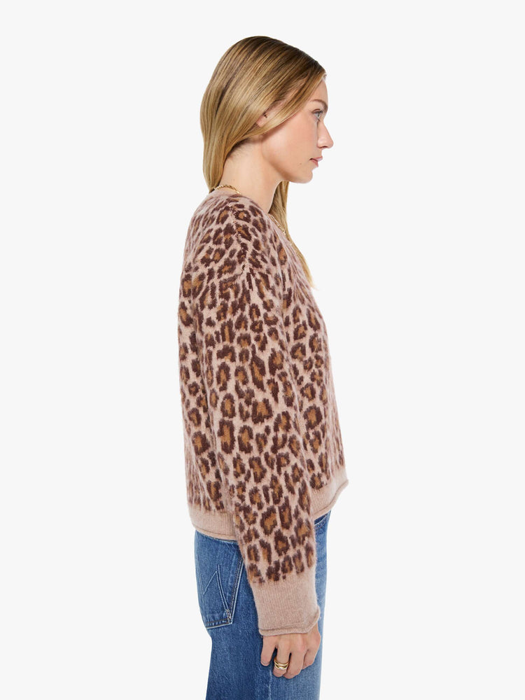 Side view of a woman in a cheetah print sweater designed with drop shoulders, ribbed hems and a slouchy fit.