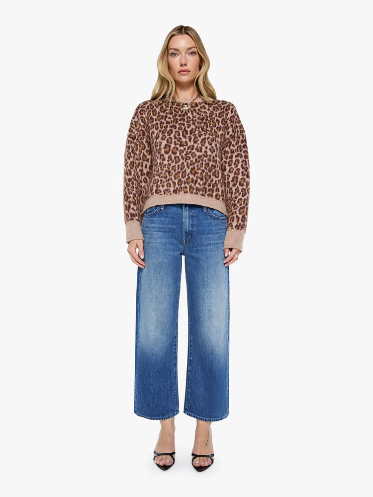 Full body view of a woman in a cheetah print sweater designed with drop shoulders, ribbed hems and a slouchy fit.