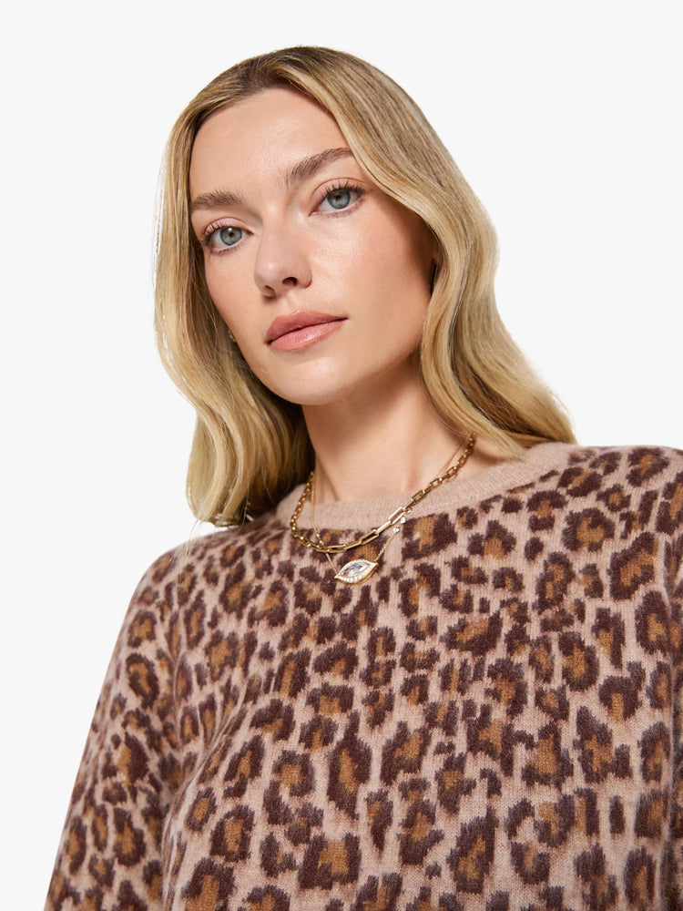 Side view of a woman in a cheetah print sweater designed with drop shoulders, ribbed hems and a slouchy fit.