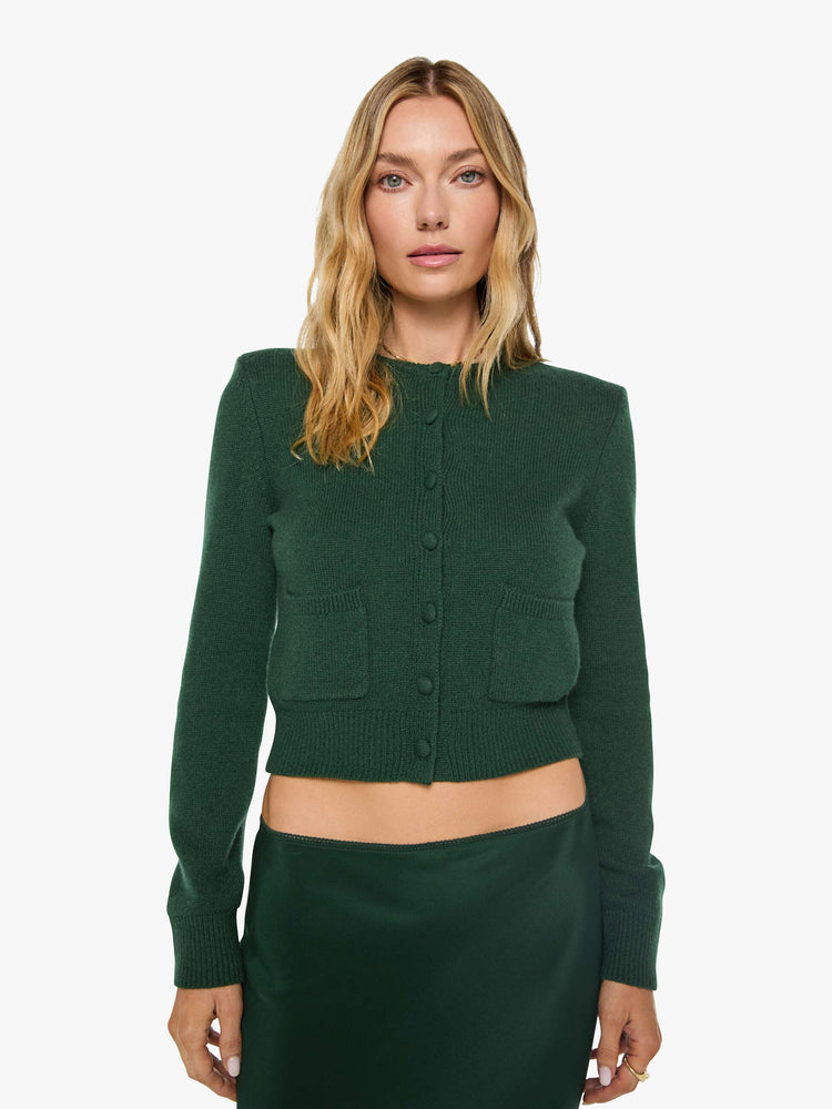 Front view of a woman in green cardigan is designed with a crewneck, long sleeves, ribbed hems and a cropped fit.