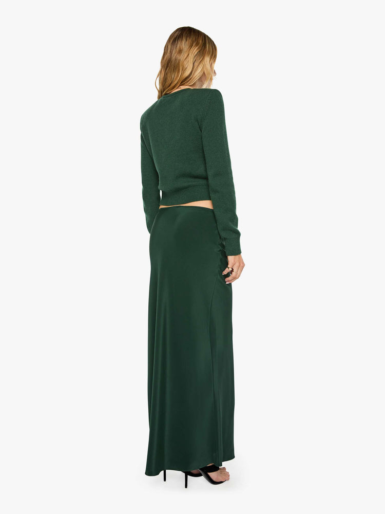 Back view of a woman in a low-rise maxi skirt is designed with a straight fit and a flowy, floor-length hem.