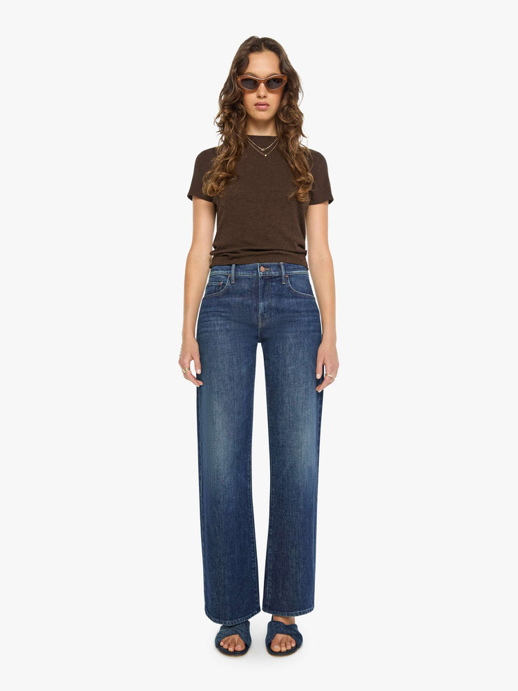 Full body view of a woman in a brown baby tee from SPRWMN with a hip-length hem, short sleeves and a semi-fitted shape.