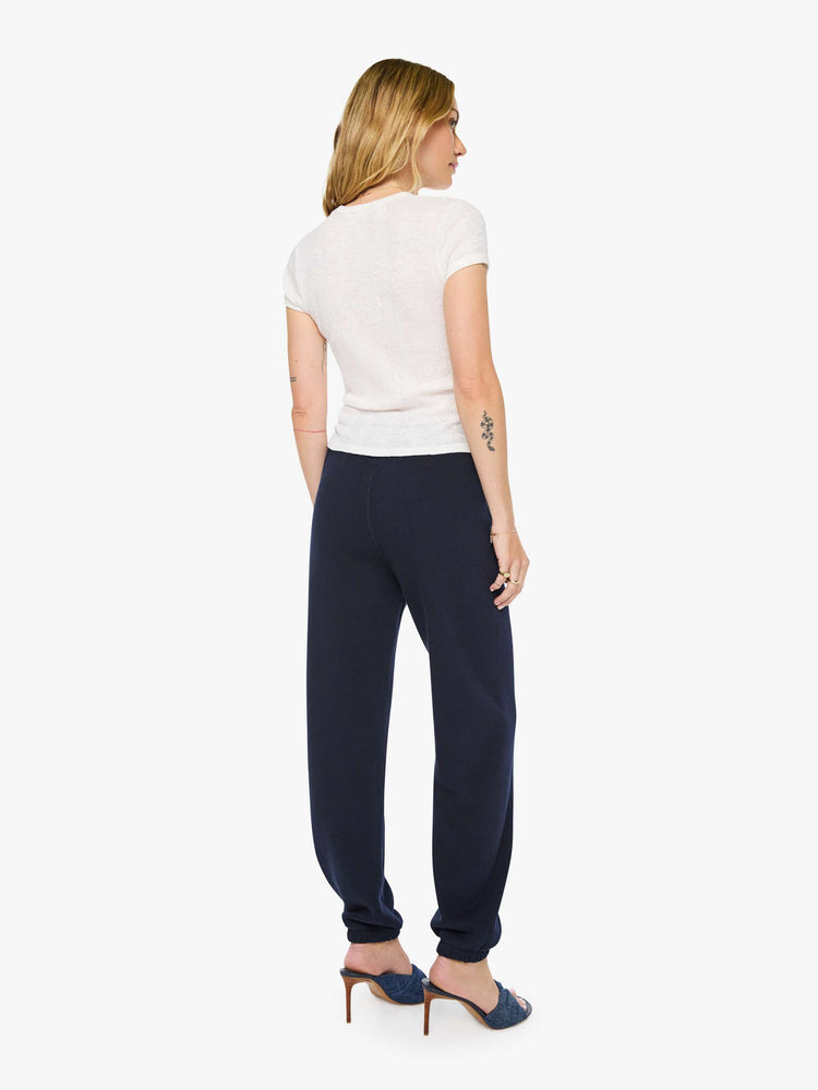 Back view of a woman in a navy with white heart on the hip sweatpants have an elastic waist and cuffs for a loose, comfortable fit.