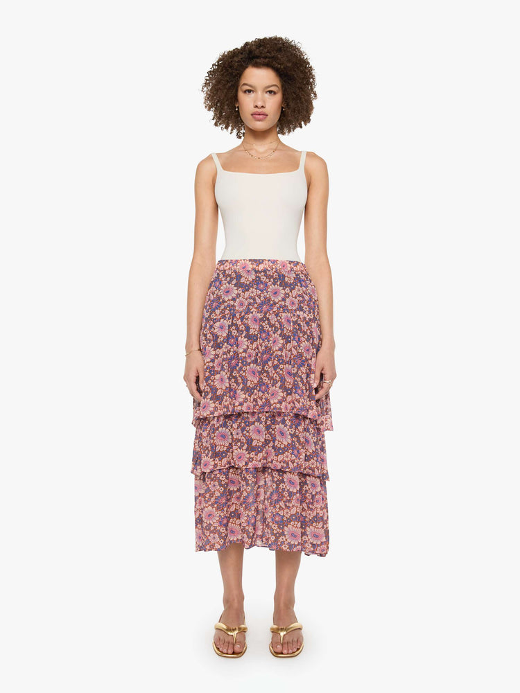 Front view of a woman in a warm-toned floral print, the Gretchen skirt features a high rise, calf-grazing hem, oversized tiers and a loose, flowy fit.