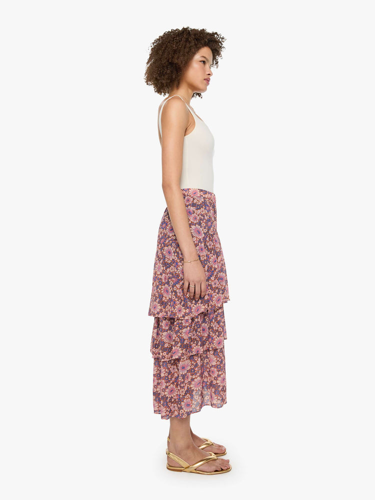 Side view of a woman in a warm-toned floral print, the Gretchen skirt features a high rise, calf-grazing hem, oversized tiers and a loose, flowy fit.