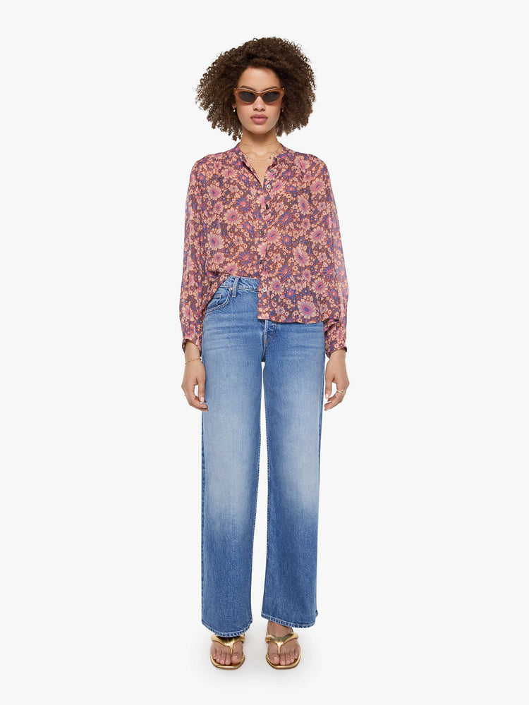 full body view of a woman in warm-toned floral print button up top with a V-neck, long balloon sleeves and curved hem with a light and airy fit.