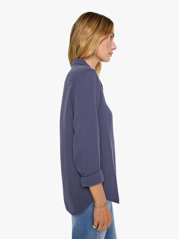 Side view of a woman in charcoal blue long-sleeve shirt features a V-neck and curved hem with a light and airy fit.