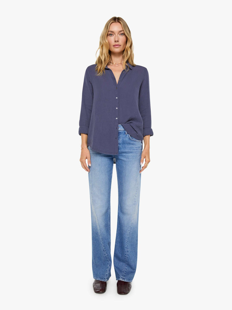 Full body view of a woman in charcoal blue long-sleeve shirt features a V-neck and curved hem with a light and airy fit.