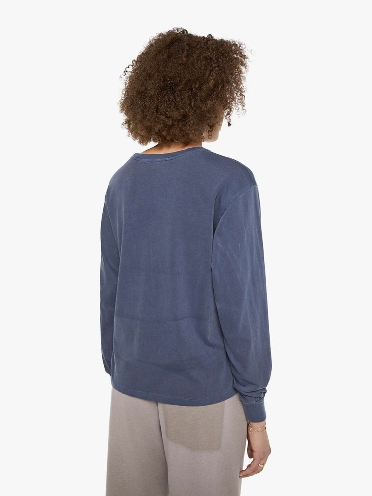 Back view of a woman in a tee is designed in a sun-faded navy with the brand's logo and text in yellow on the chest.