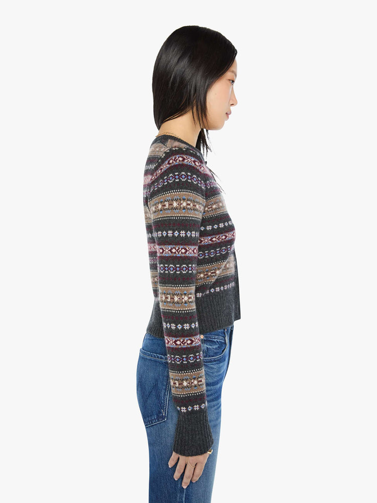 Side view of a woman in a black with horizontal knit details cardigan designed with a crewneck, long sleeves, ribbed hems and a cropped fit.