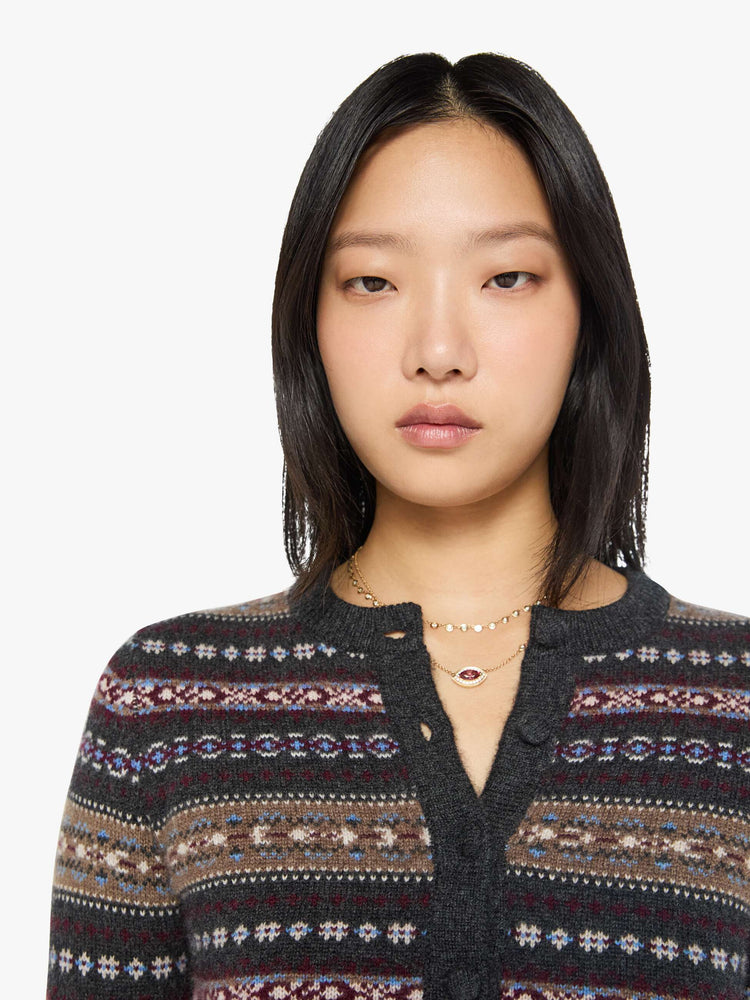 Close up view of a woman in a black with horizontal knit details cardigan designed with a crewneck, long sleeves, ribbed hems and a cropped fit.