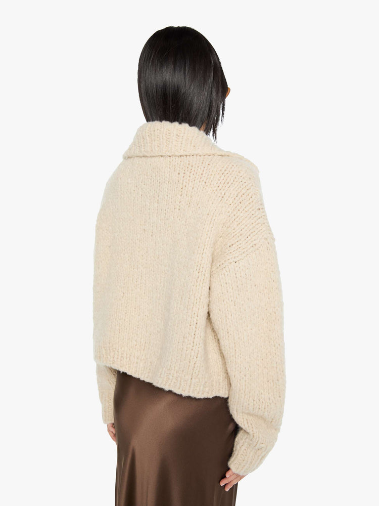 Back view of a woman in a jacket designed with a collared neck, drop shoulders, ribbed hems and a boxy fit.