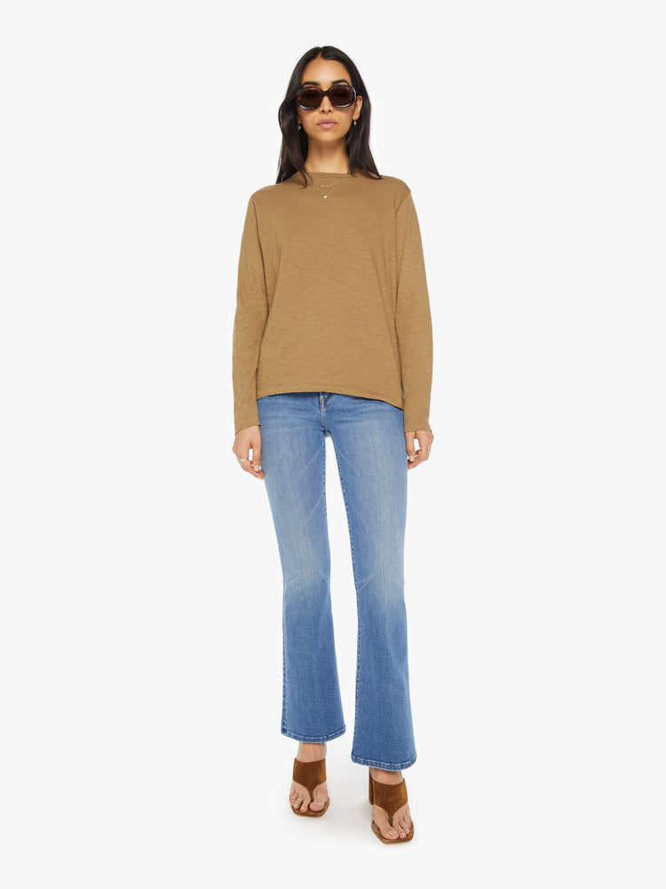 Full body view of a woman olive long-sleeve crewneck with a slightly boxy shape.