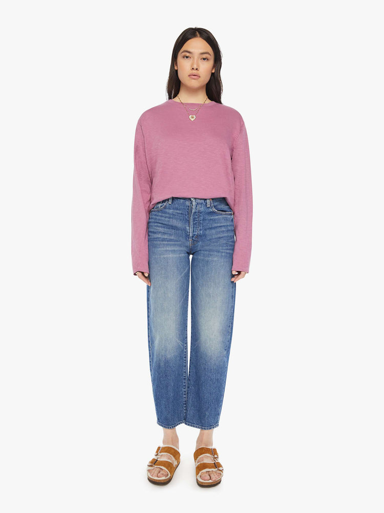 Full body view of a woman plum long-sleeve crewneck with a slightly boxy shape.