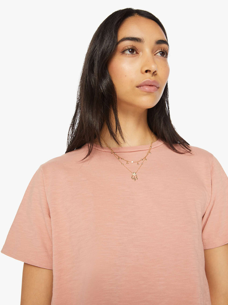Close up view of a woman crewneck in a faded peach tee with a slightly boxy shape.
