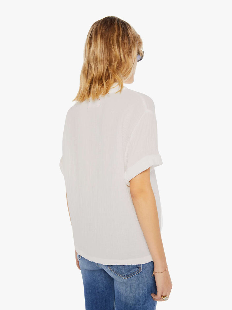 Back view of a womens cream blouse featuring a deep v neck and cuffed short sleeves.