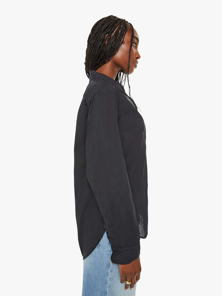 Side view of a woman black button-down long sleeve shirt is light and airy with a loose fit.