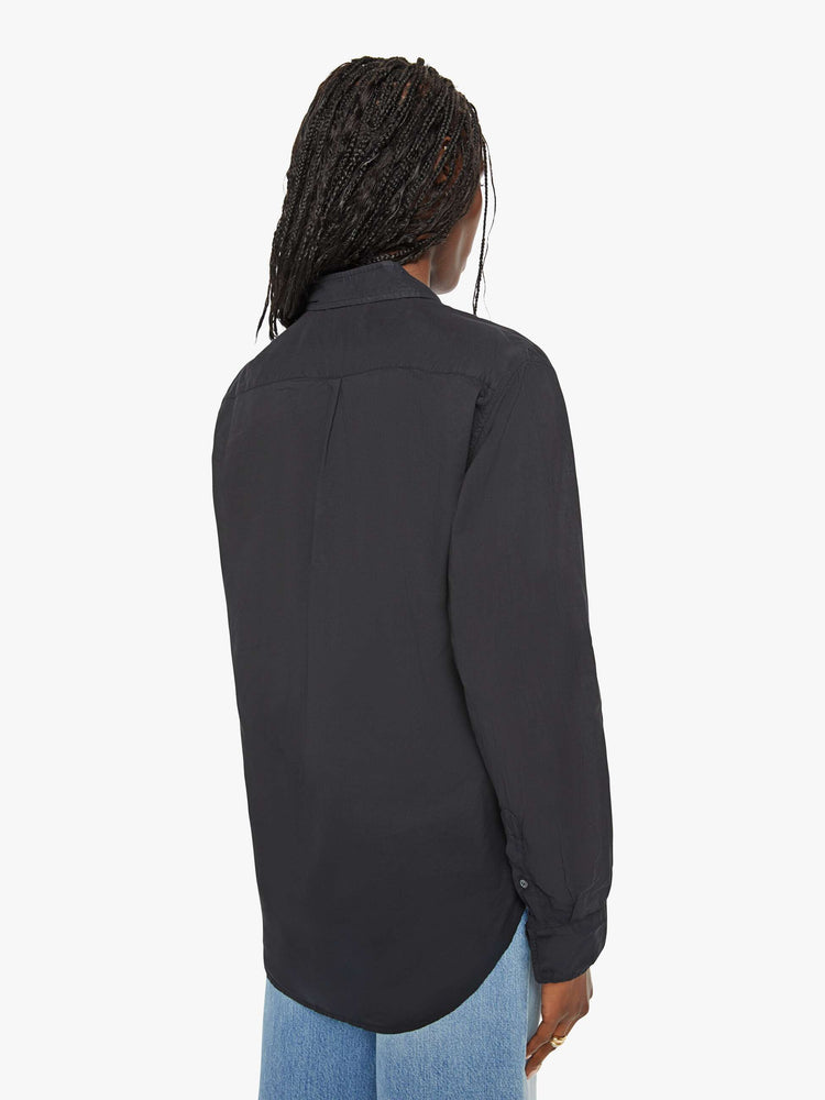 Back view of a woman black button-down long sleeve shirt is light and airy with a loose fit.