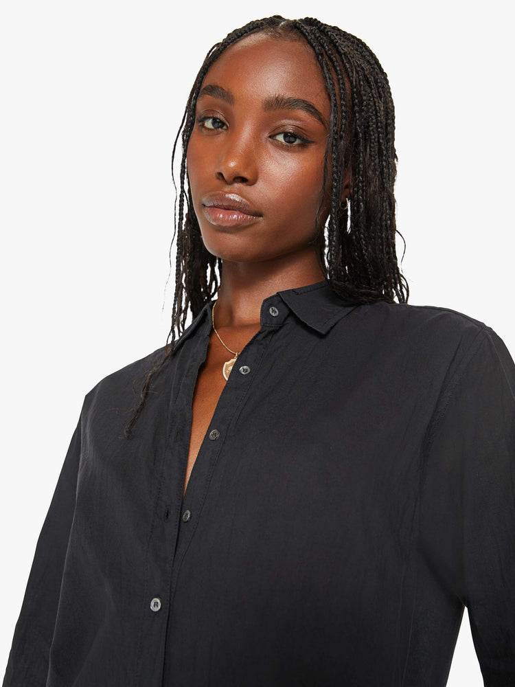 Close up view of a woman black button-down long sleeve shirt is light and airy with a loose fit.