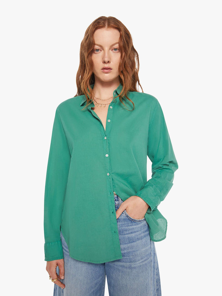 Front view of woman in a  green button-down long sleeve shirt.