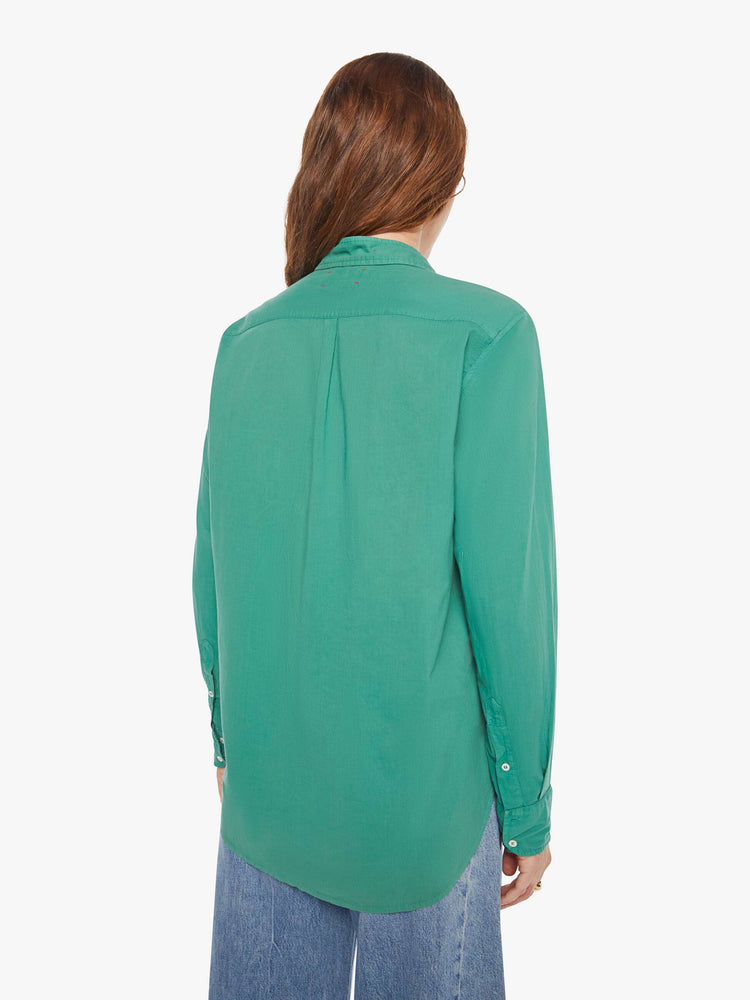 Back view of woman in a  green button-down long sleeve shirt.