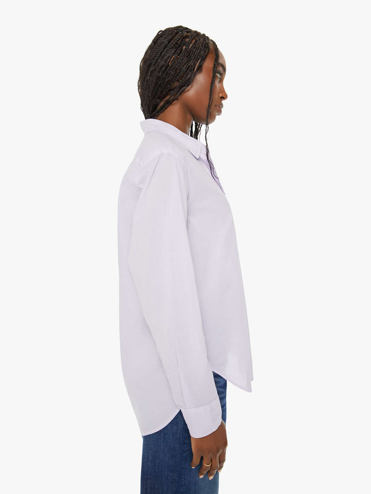 Side view of a woman light-blue button-down long sleeve shirt is light and airy with a loose fit.