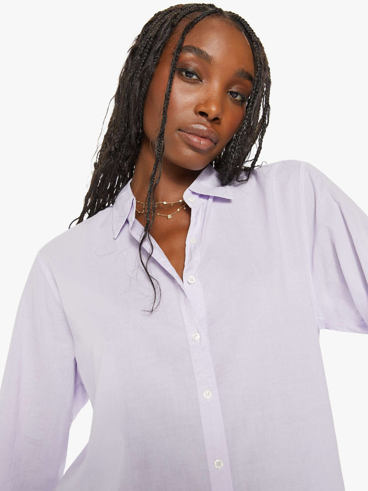 Close up view of a woman light-blue button-down long sleeve shirt is light and airy with a loose fit.