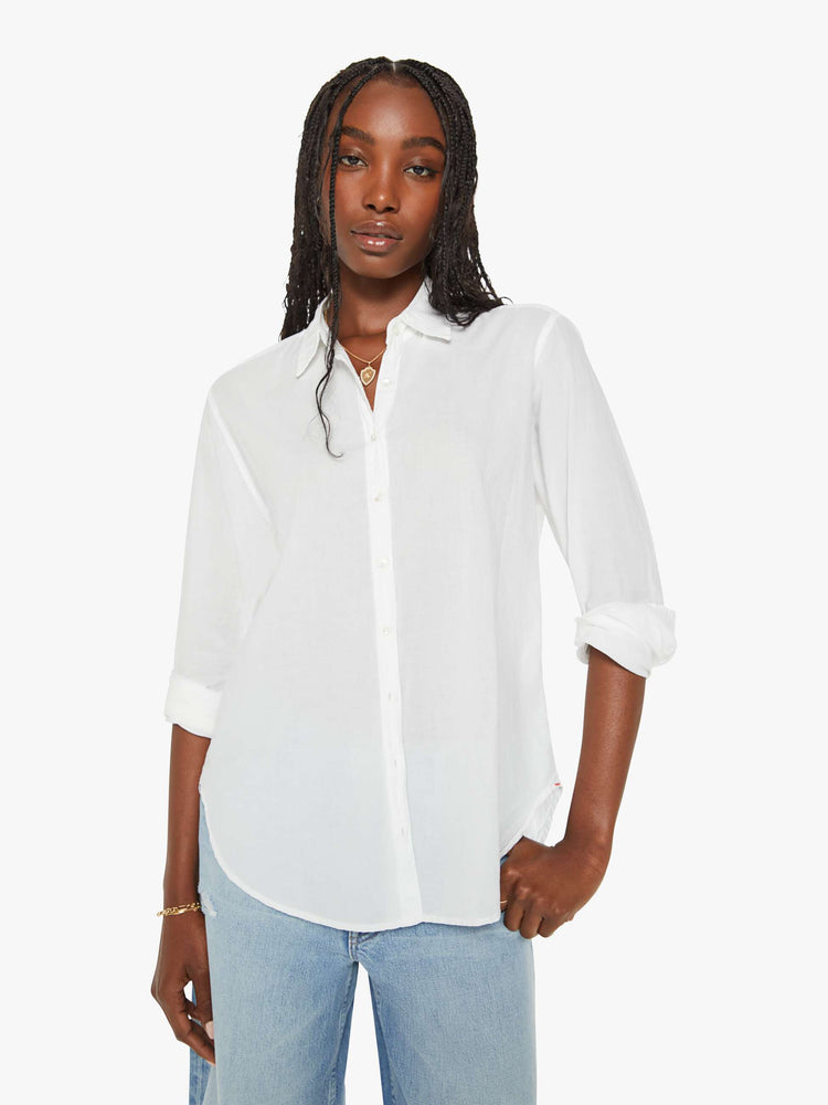 Front view of a woman white button-down long sleeve shirt is light and airy with a loose fit.