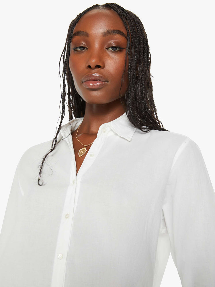 Close up view of a woman white button-down long sleeve shirt is light and airy with a loose fit.