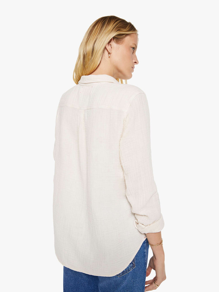 Back view of a woman in a long sleeve off-white button-down.