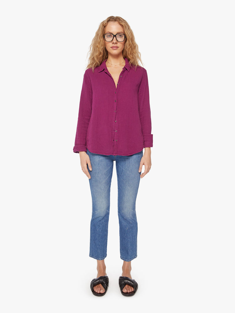 Full body view of a woman plum button down long sleeve shirt with a Vneck and curved hem.
