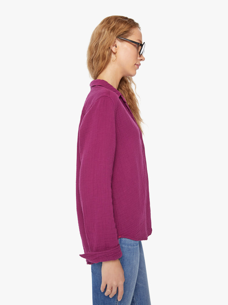 Side view of a woman plum button down long sleeve shirt with a Vneck and curved hem.