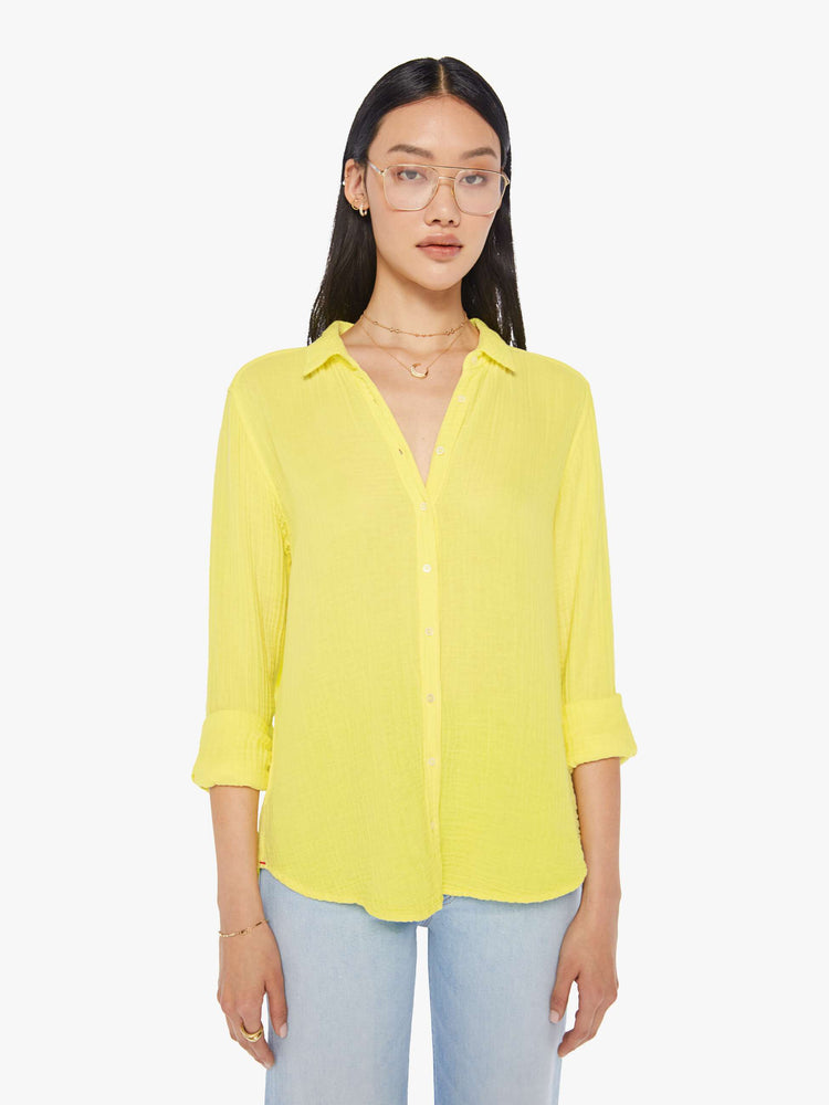 Front view of a womens bright yellow button down long sleeve shirt with a curved hem.