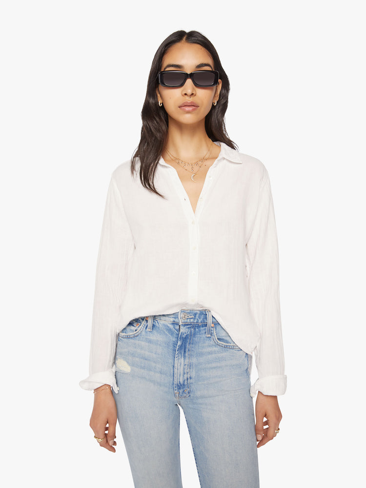 Front view of a woman white button-down features a V-neck and curved hem with a light and airy fit.