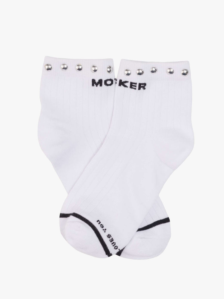 Clos up view of a MOTHER's classic black and white tube sock now in an ankle style with metal studs along the hem.