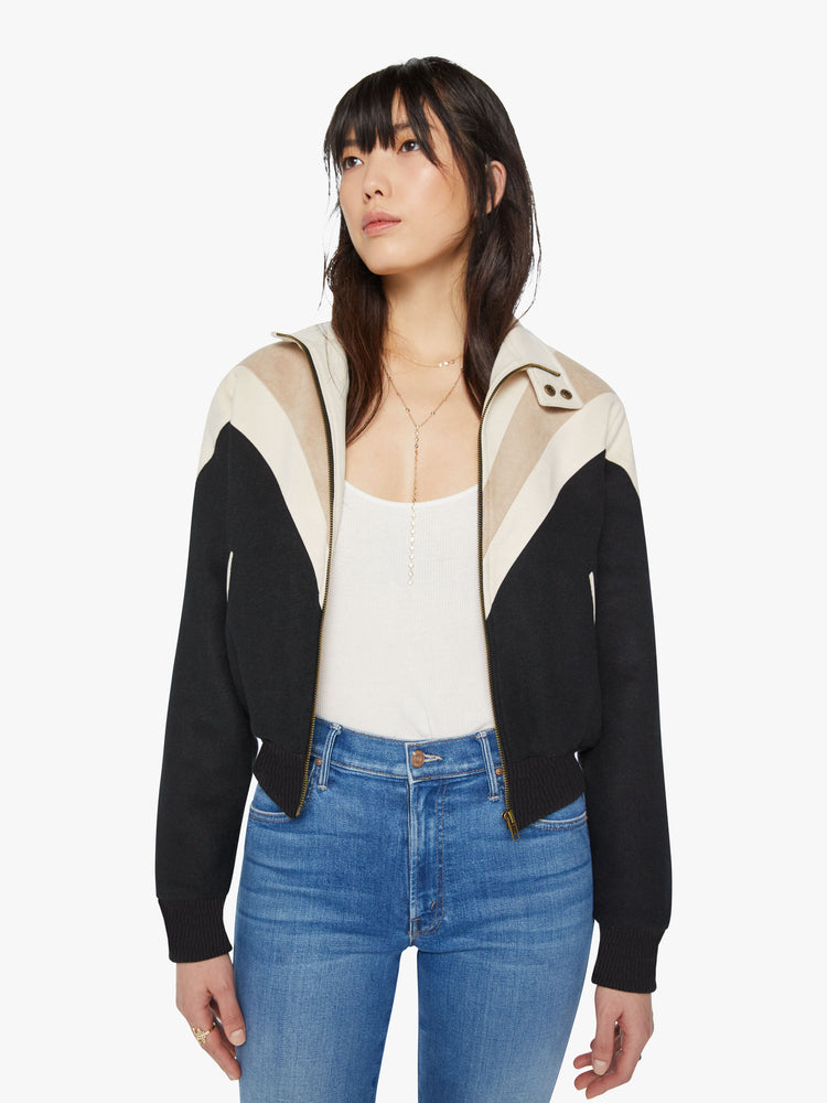 Front view of a woman letterman jacket with a stacked collar that buttons, subtle drop shoulders, side slit pockets, a cropped fit and zip closure in a black hue.