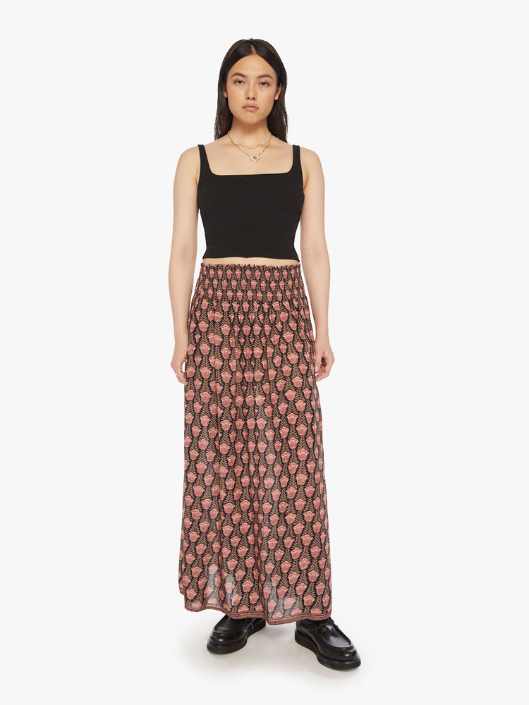 Front view of a woman pink tulip print skirt features a smocked waistband and a loose, flowy fit.