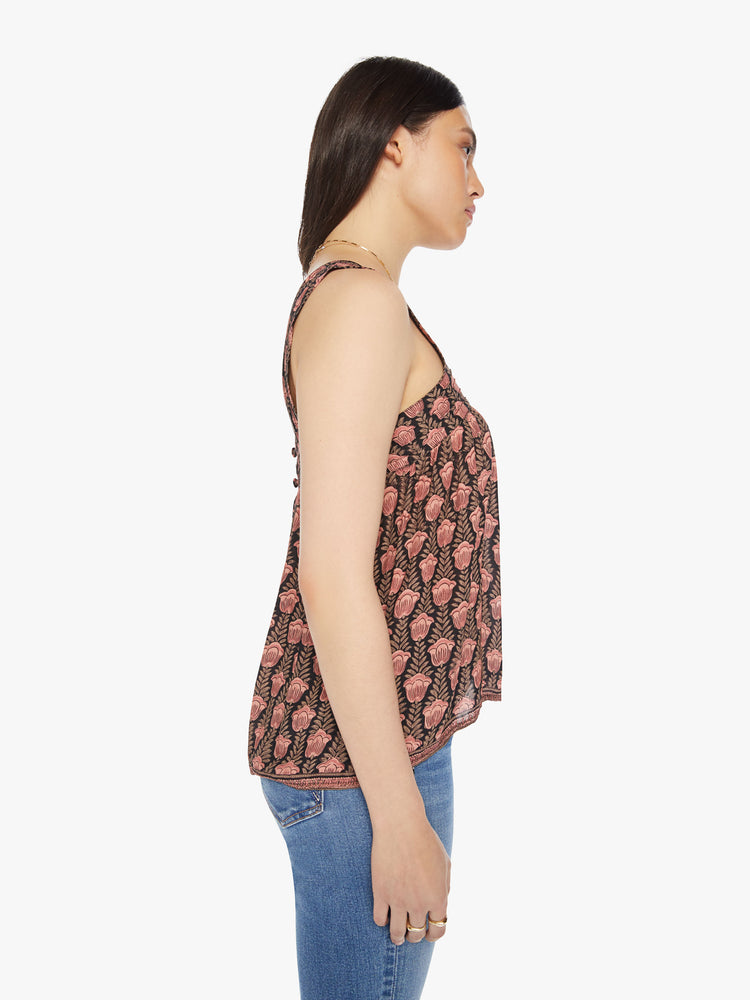 Side view of a woman top designed in brown with a baby pink tulip print, and features detailed straps and buttons in the back.